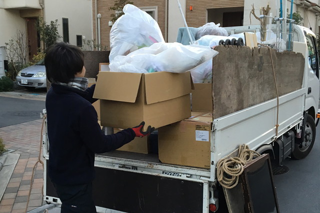 不用品の入った段ボール箱をトラックに積んでいる写真